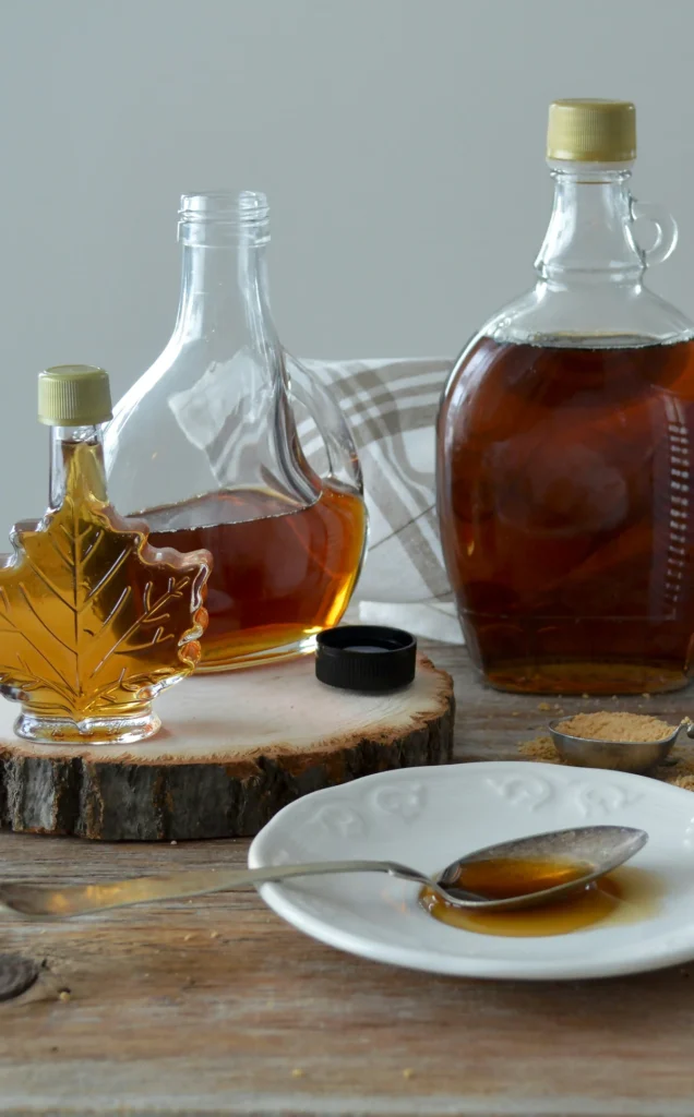 Bouteilles de sirop d’érable sur table en bois