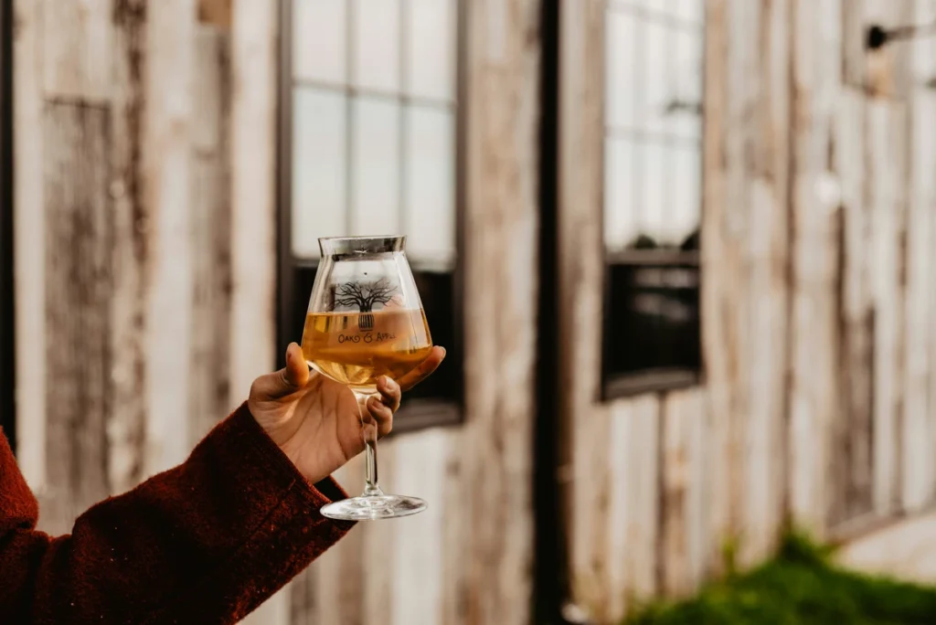 Main tenant un verre de vin blanc
