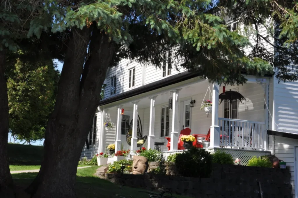 Maison blanche avec véranda et jardin fleuri