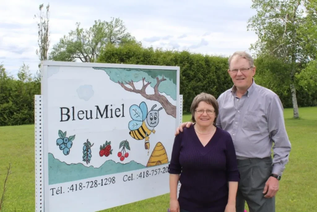 Couple devant panneau BleuMiel avec abeille dessinée