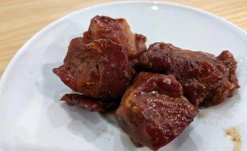 Morceaux de viande caramélisée sur assiette blanche