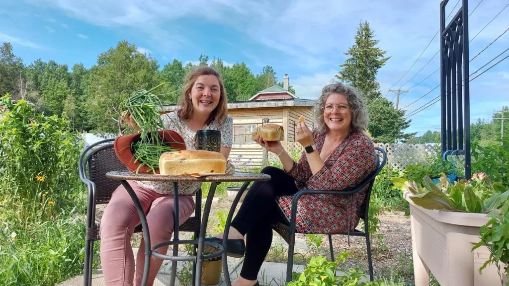 Deux femmes dégustant du pain au jardin