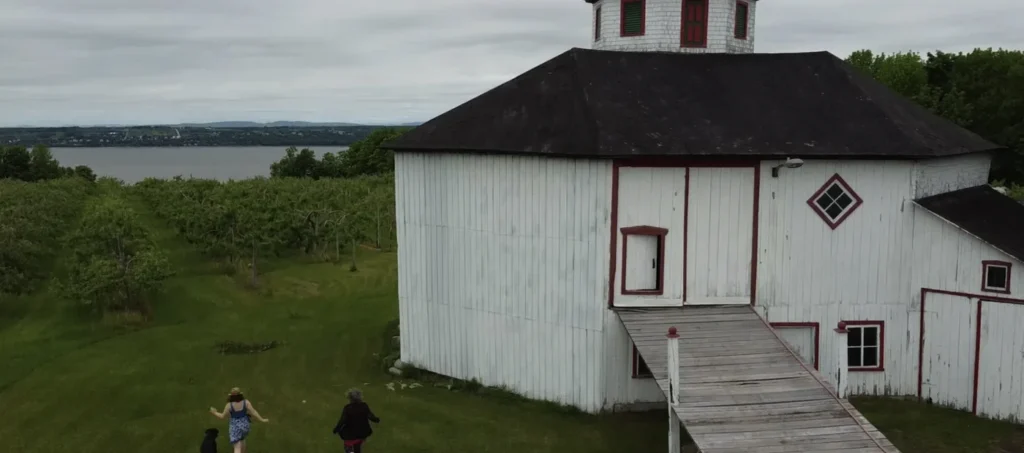 Grand bâtiment blanc près d’un verger et rivière