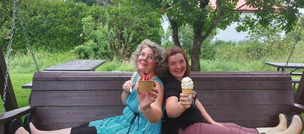 Deux femmes souriantes dégustant des glaces dehors