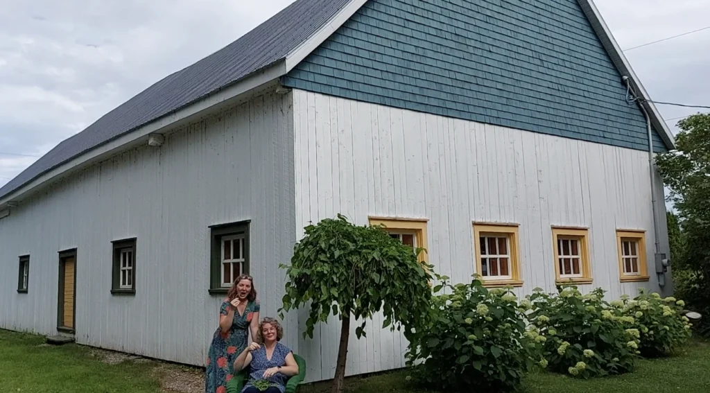Deux femmes devant maison blanche en bois