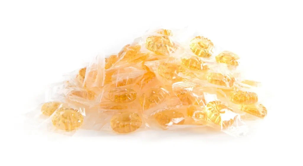 Bonbons jaunes emballés individuellement sur fond blanc