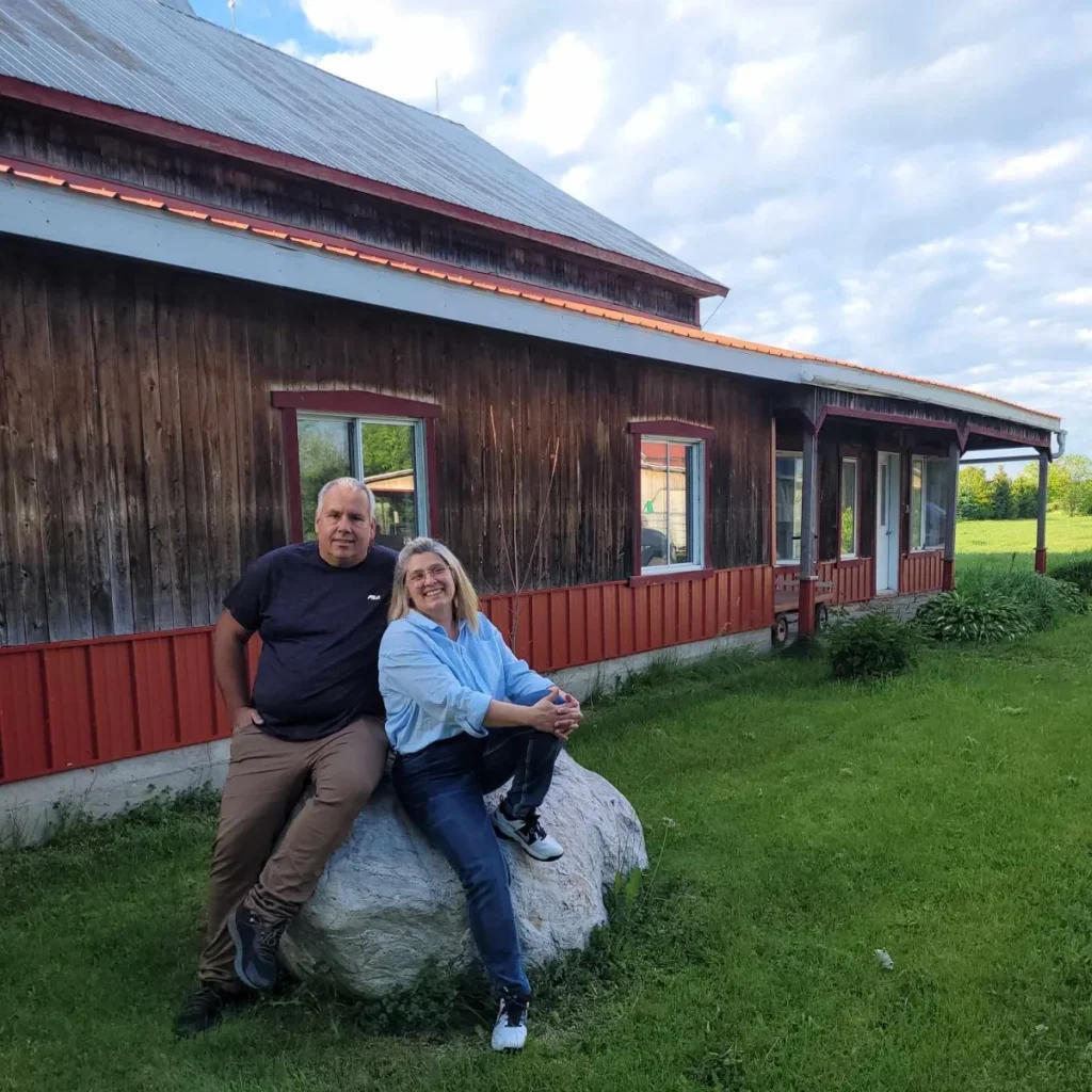 Couple assis devant maison en bois rustique