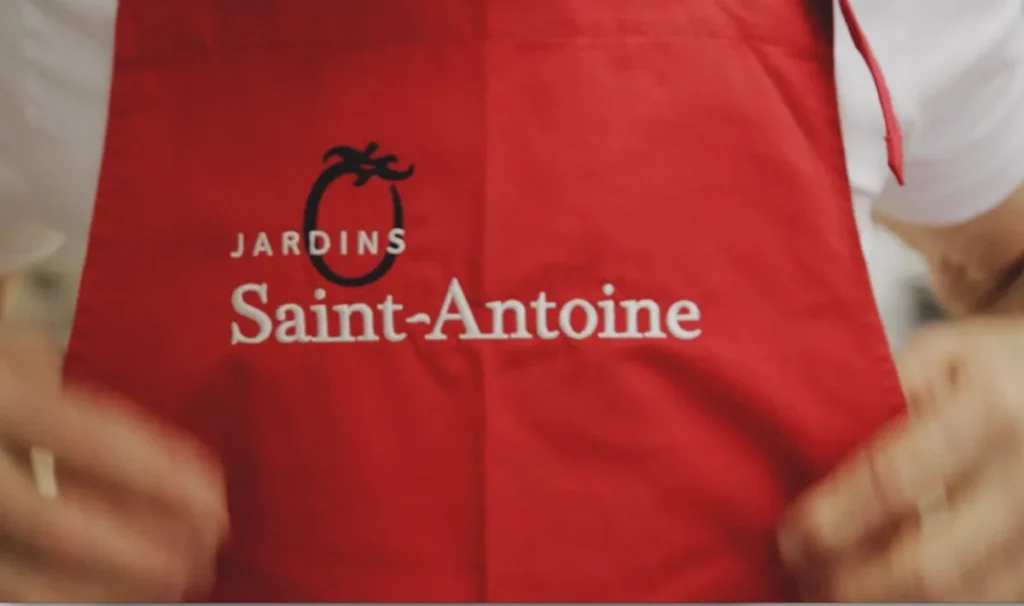Tablier rouge Jardins Saint-Antoine avec logo tomate