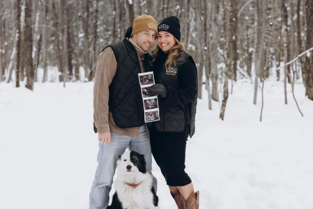 Couple souriant avec échographies dans forêt enneigée