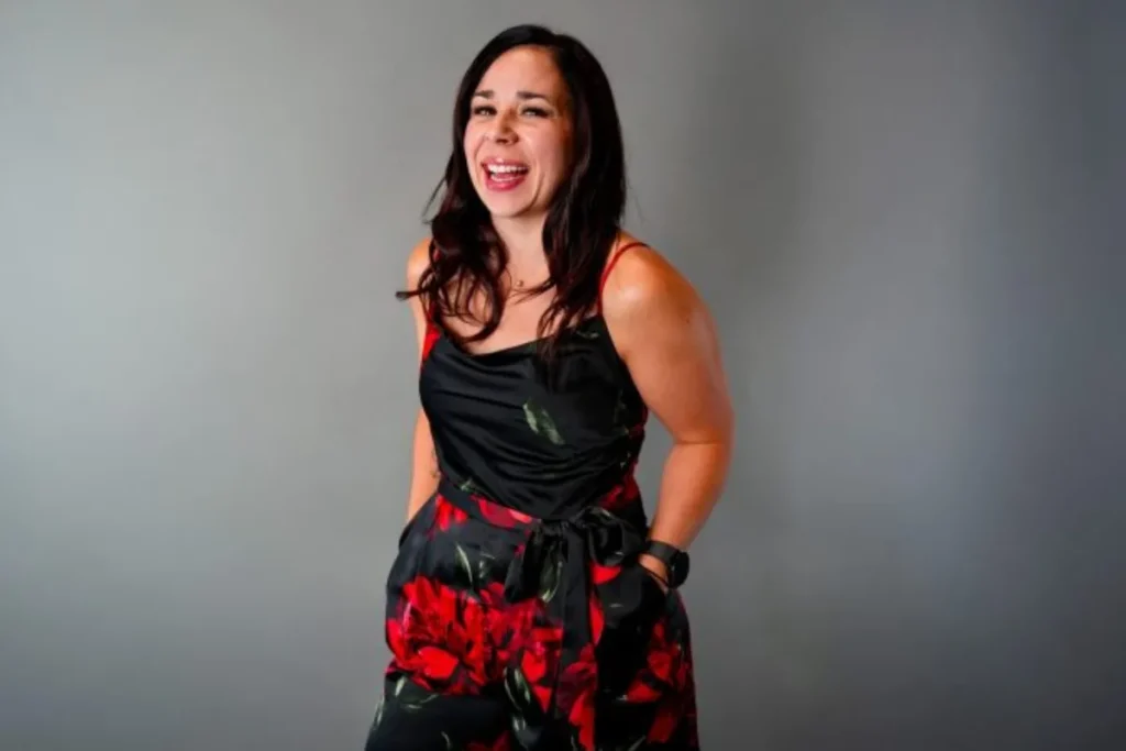 Femme souriante en robe noire à fleurs rouges