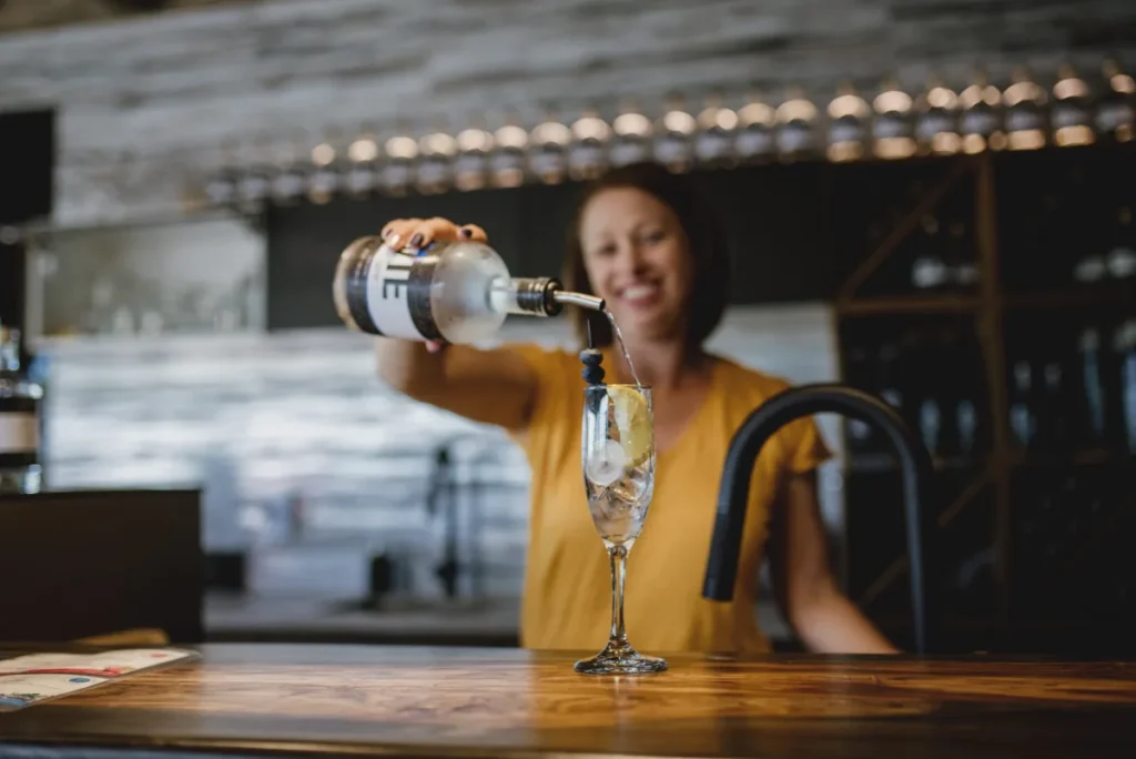 Femme versant du gin dans un verre