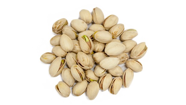 Pistaches entières avec coquille sur fond blanc